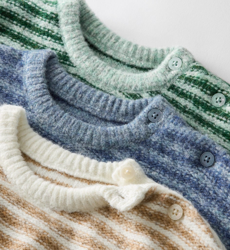 3 baby knitwear sweaters stacked on top of each other in varying colors