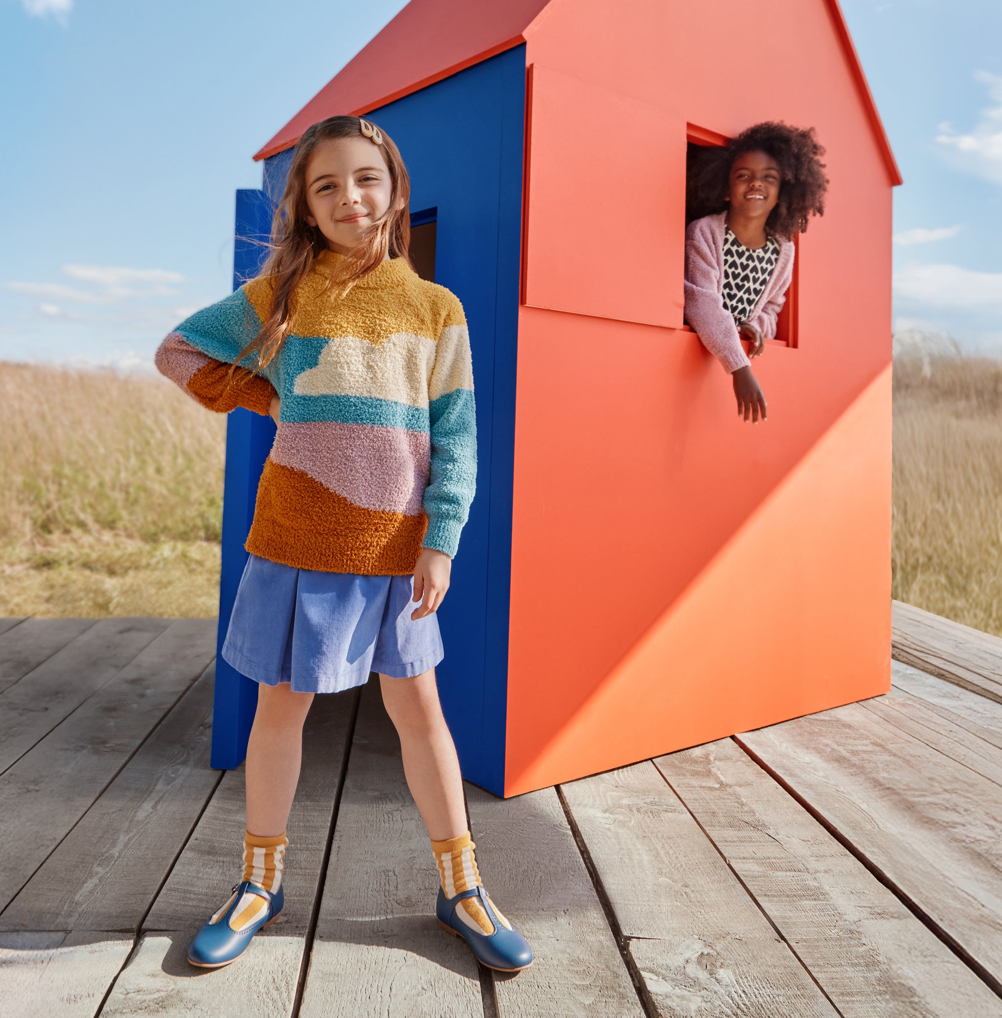 Children playing in a house on a field