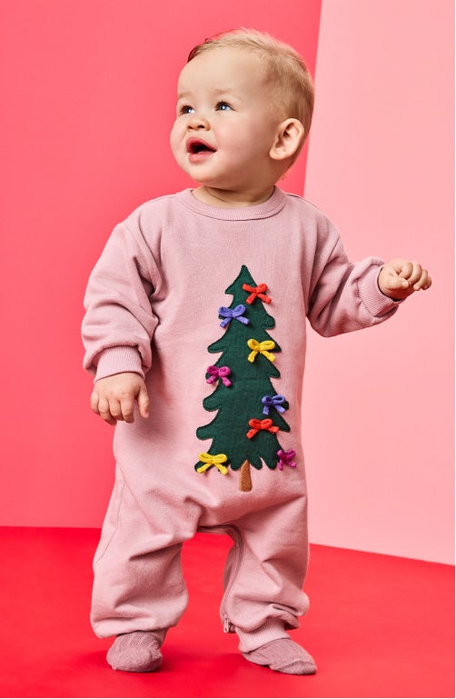 baby in pink onesie with christmas tree on the front