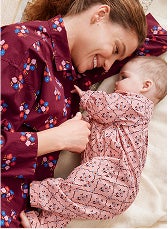 A mother lying in bed with baby in their pajamas