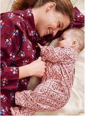 A mother lying in bed with baby in their pajamas