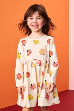 girl in long sleeve pumpkin printed dress
