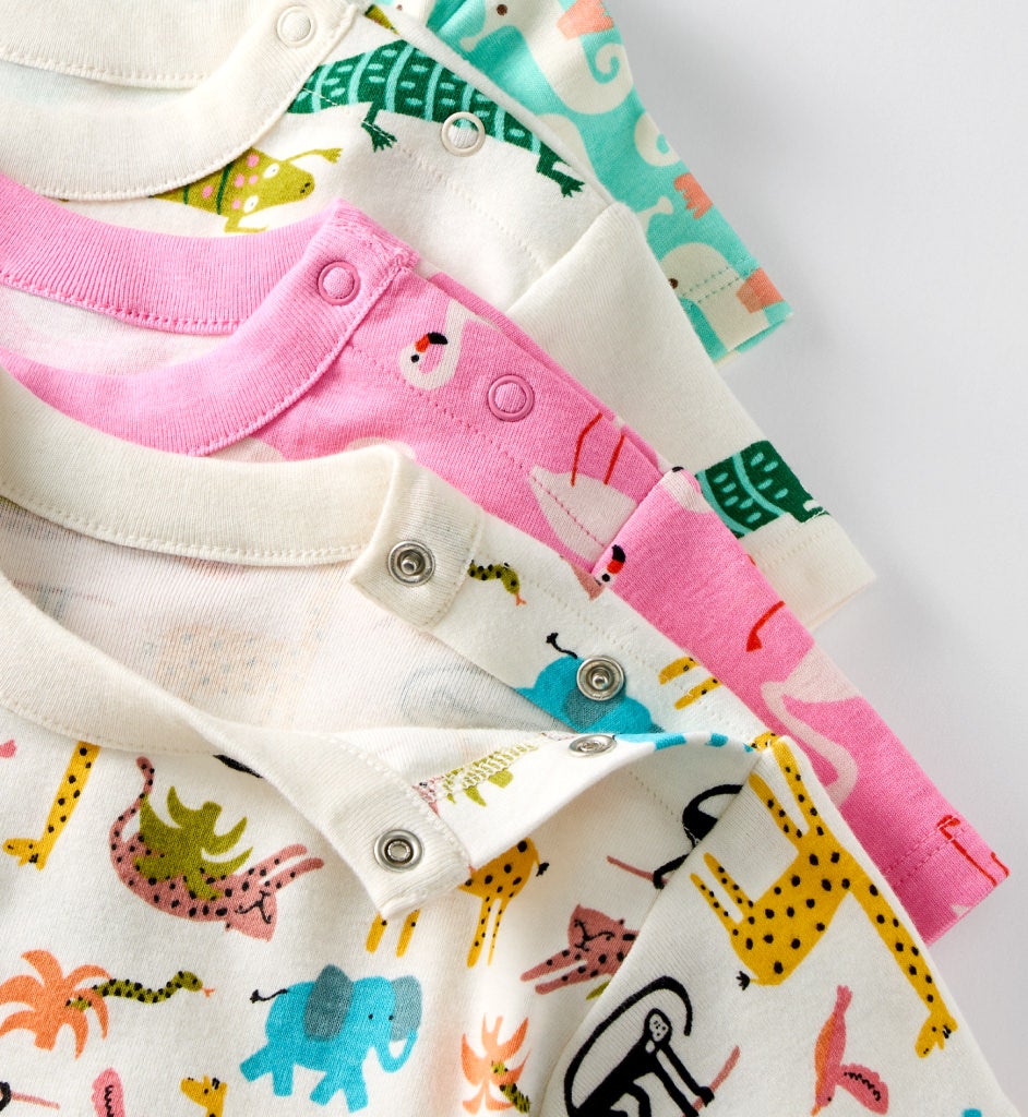 stack of baby bodysuits in various prints detail shot