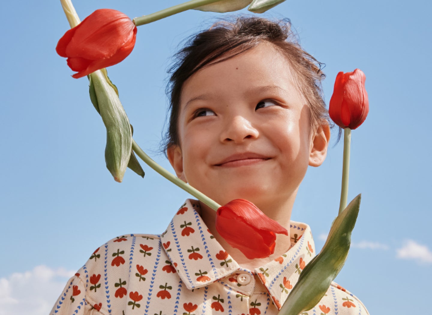 Child with roses framing face
